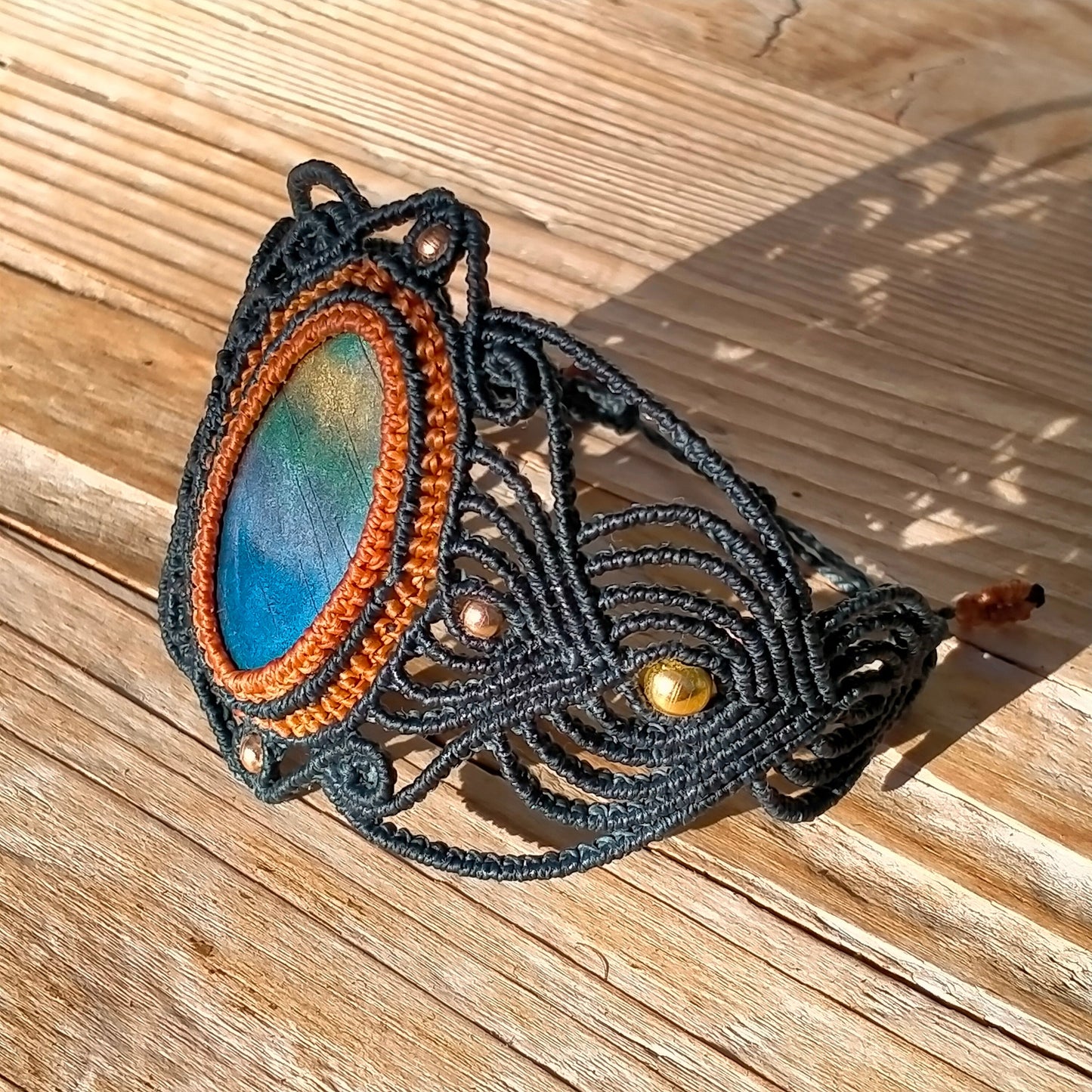Détail bracelet macramé artisanal, perles métalliques, imitation labradorite, fermoir ajustable