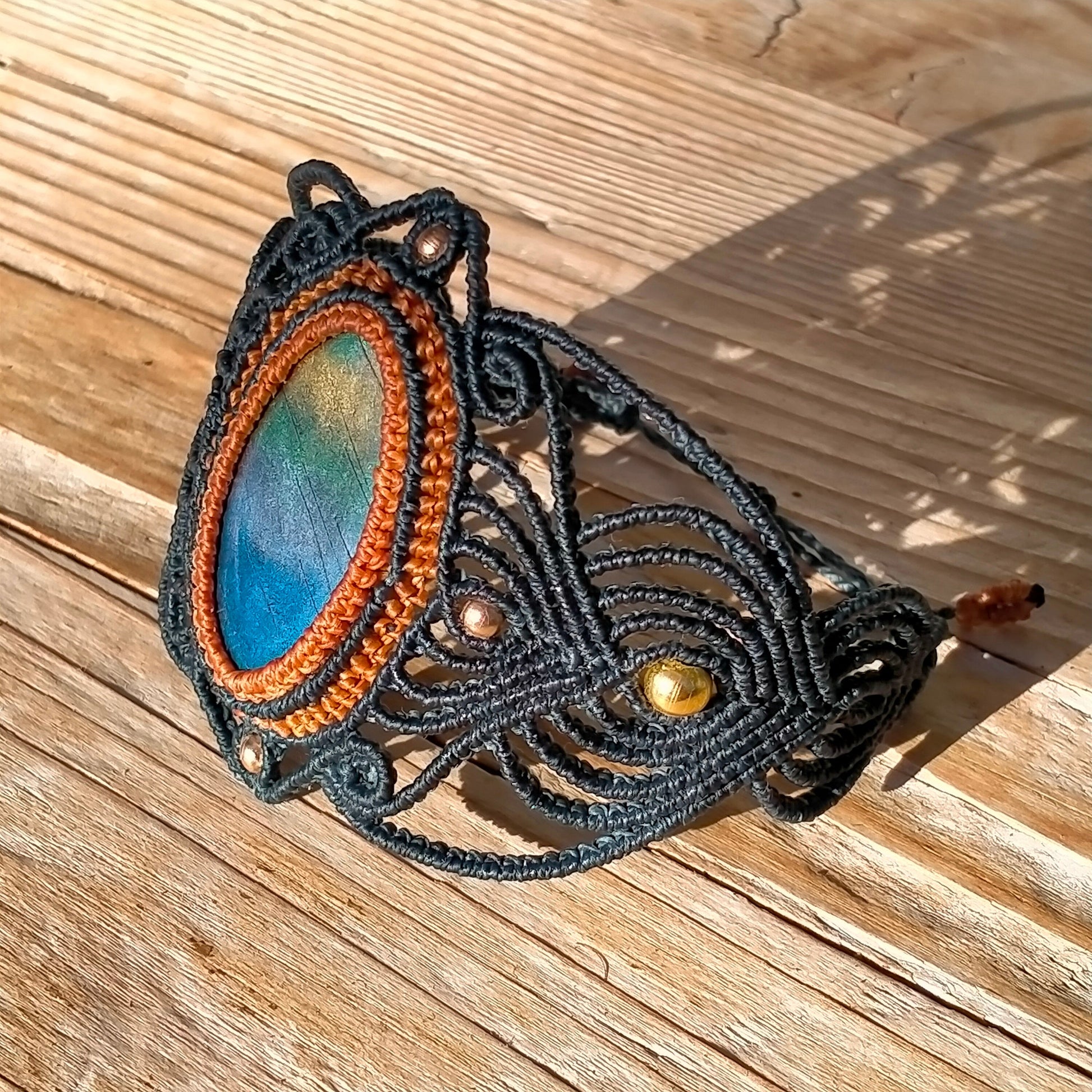 Détail bracelet macramé artisanal, perles métalliques, imitation labradorite, fermoir ajustable